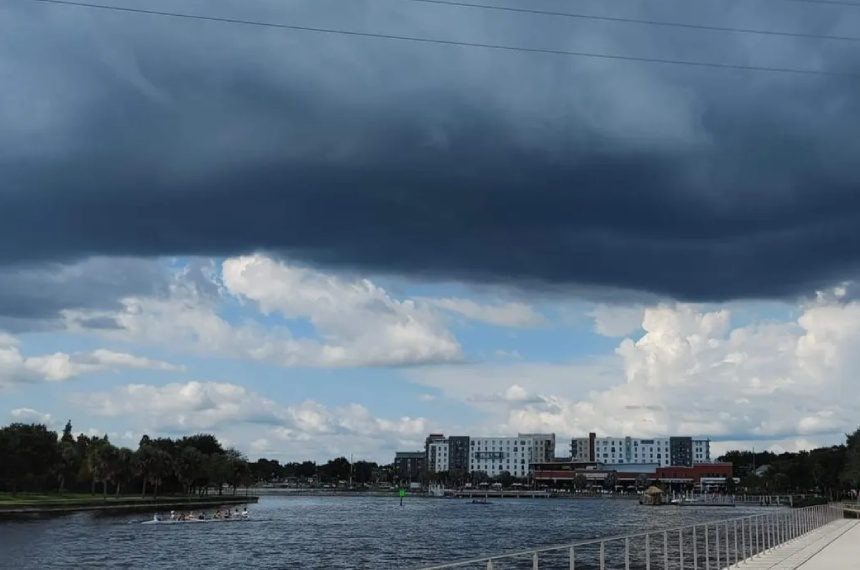 A cloudy sky over the water and buildings.