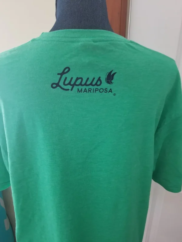 A person wearing a green shirt with lupus mariposa on it.