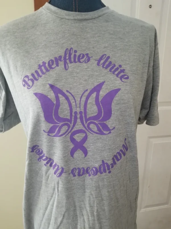 A t-shirt with the words butterflies unite and an awareness ribbon.