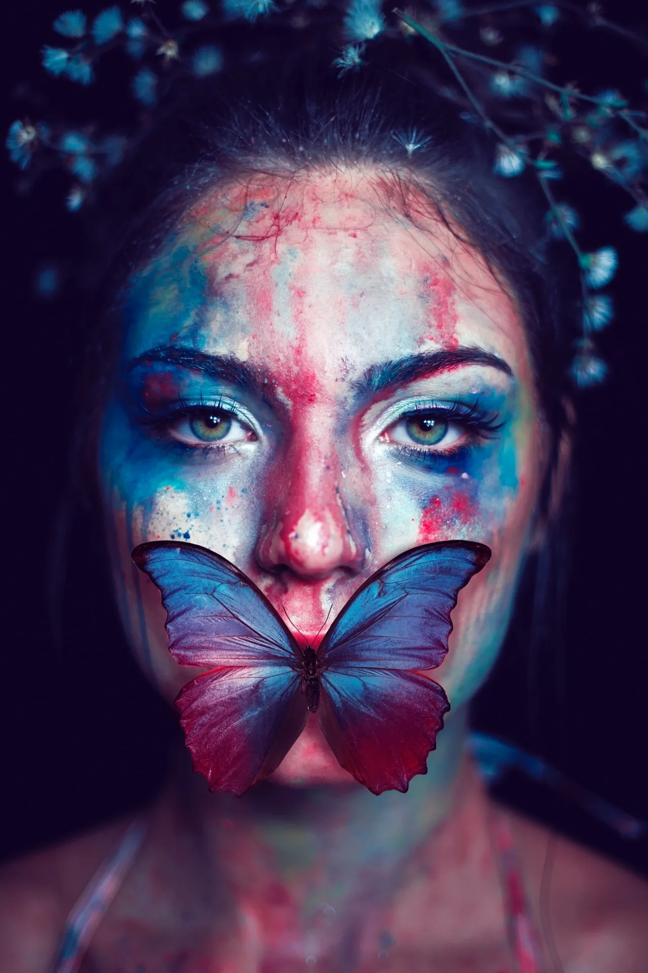 Woman with colorful face paint and butterfly.