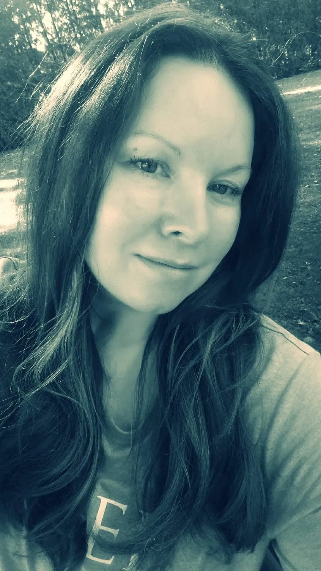 Woman with long brown hair smiling.