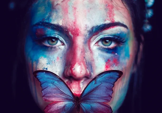 Woman with colorful face paint and butterfly.