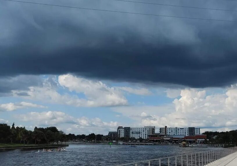 A cloudy sky over the water and buildings.